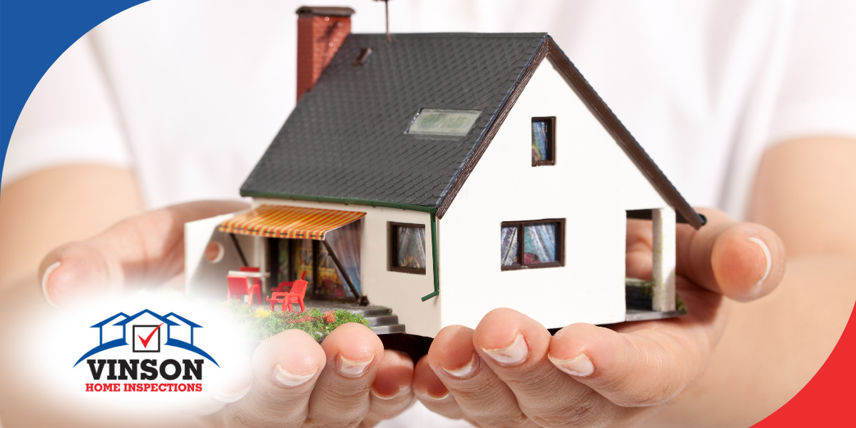 Hands holding a model house representing home protection and inspection services.