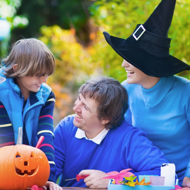 Family enjoying Halloween pumpkin carving outdoors
