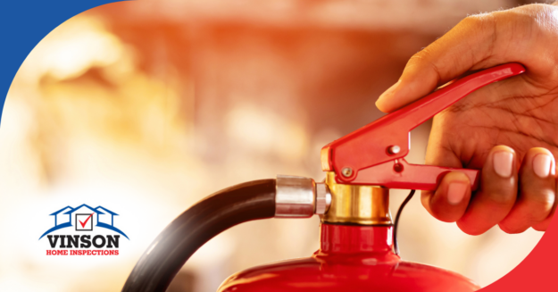 Close-up of a hand operating a red fire extinguisher