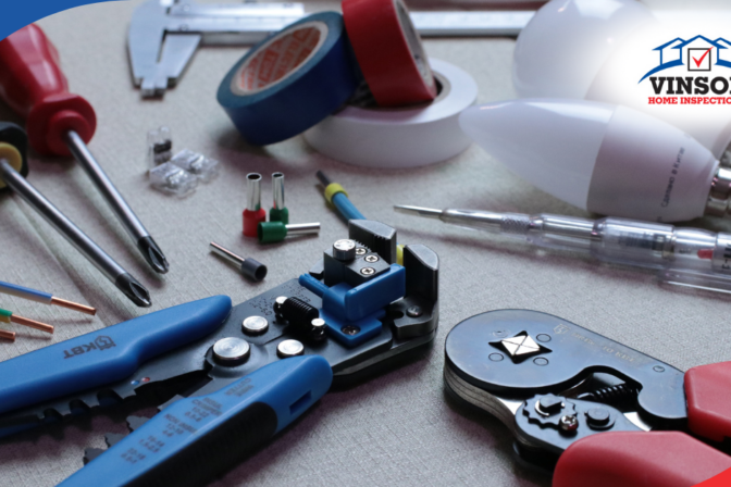 Electrical tools, wires, and light bulbs arranged on a work surface for inspection tasks.