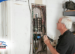 Home inspector performing an electrical panel inspection at a property