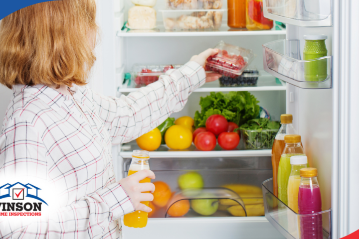 Woman placing berries in a refrigerator stocked with fruits, vegetables, and drinks.