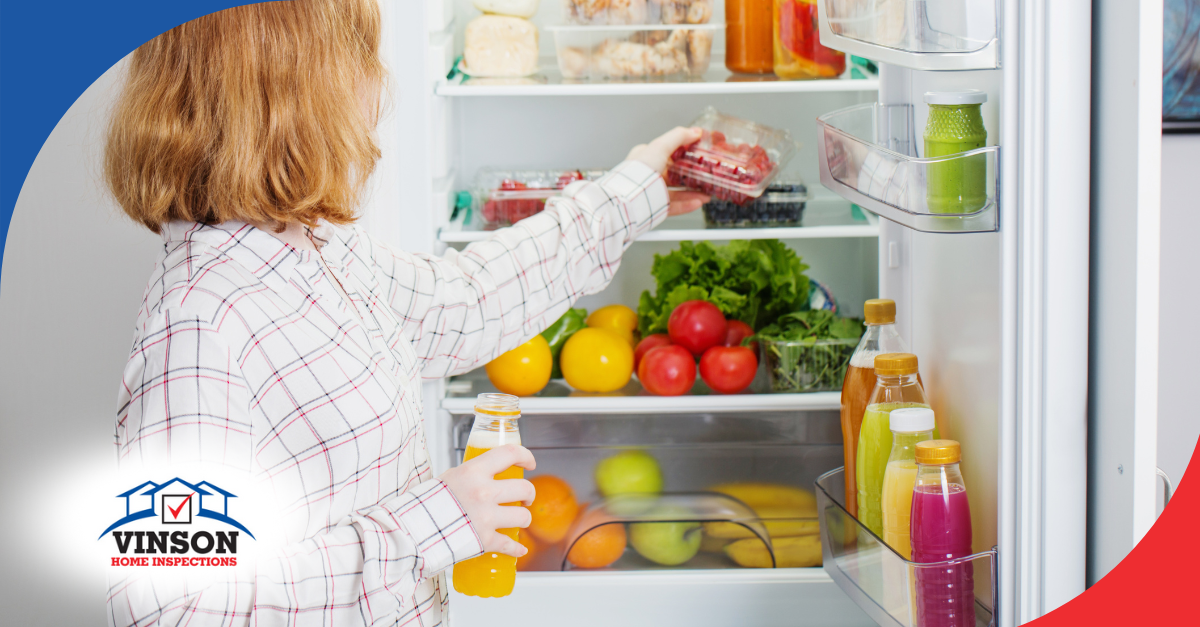 Woman placing berries in a refrigerator stocked with fruits, vegetables, and drinks.