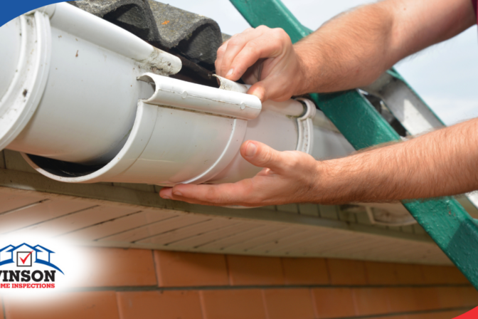 Vinson Home Inspections Hands repairing a white plastic roof gutter.
