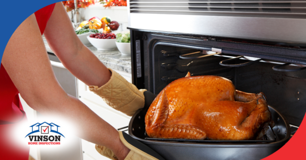 Vinson Home Inspections Person removing a golden roasted turkey from the oven, with a kitchen counter full of fresh produce in the background.